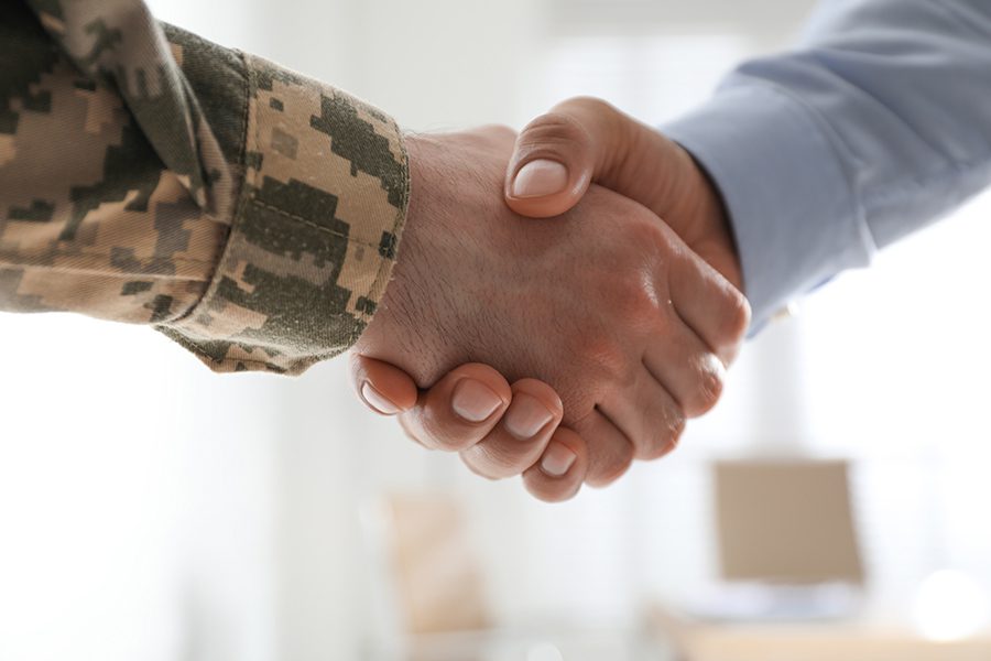 Ensuring Veterans - Close Up of a Veteran Shaking Hands with a Busienss Man in an Office